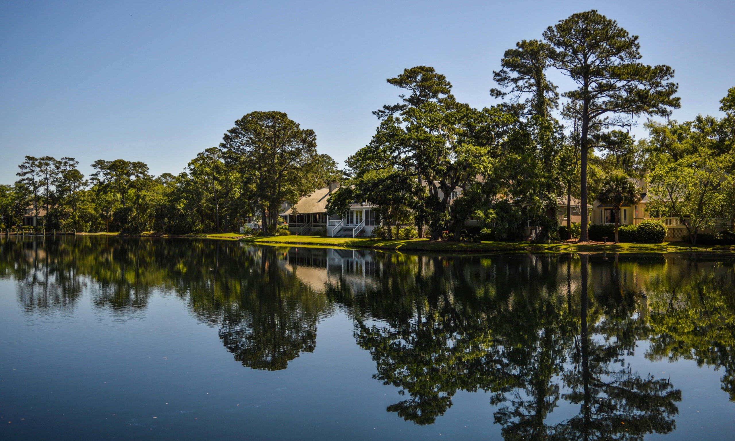 Lake with trees and lake house in the background.